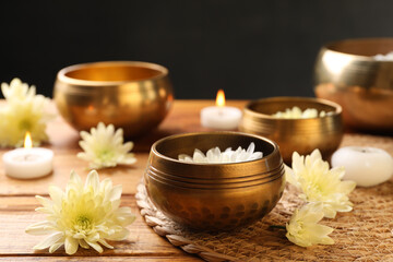 Tibetan singing bowls and beautiful chrysanthemum flowers on wooden table