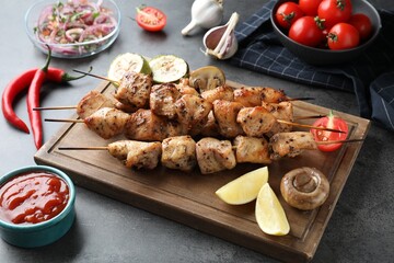 Delicious shish kebabs with vegetables served on grey table