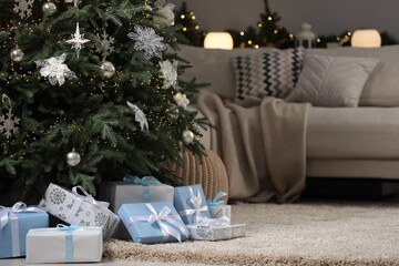 Many different gifts under Christmas tree on carpet indoors, space for text