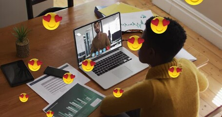 Animation of heart eyes face emojis over african american woman having video call on laptop - Powered by Adobe