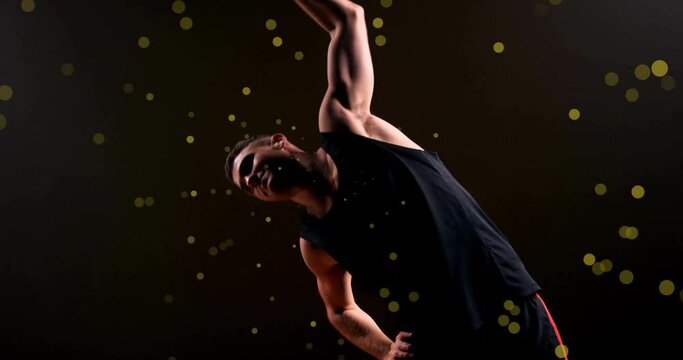 Animation of caucasian basketball player stretching and spots of light on black background