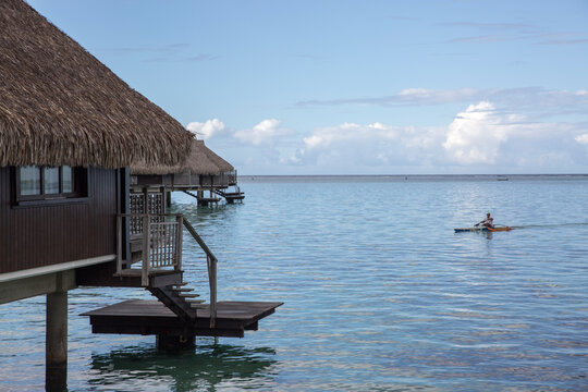 Thatched roof houses over the ocean in tropical island