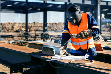 Fototapeta na wymiar Worker using a welder mask at a construction