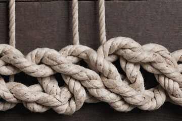 Fototapeta na wymiar twisted cotton rope knot on a wooden background
