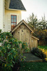 outhouse with moon cutout symbol by old building