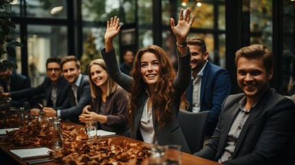 A group of people are gathered around a table strewn with autumn leaves, woman in the center raises her hands with excitement, signifying a joyful celebration or team success, corporate event, team - obrazy, fototapety, plakaty