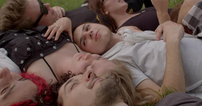 Impact of human connection on our psychological and emotional states, holistic approaches Close-up Young people lying in park. Value of physical touch and human connection overlooked in digital age. 