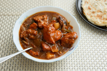 Chilly chicken with Kerala parathas porotta roti parotta barotta naan layered flatbread made from maida whole wheat flour. Eat with spicy Asian chicken beef egg curry gravy. Indian food.