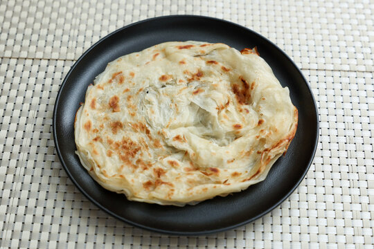 Kerala parathas / porotta / roti / parotta / barotta/ naan layered flatbread made from maida or whole wheat flour. Eat with spicy Asian chicken or beef or egg curry gravy. breakfast dish. Indian food.