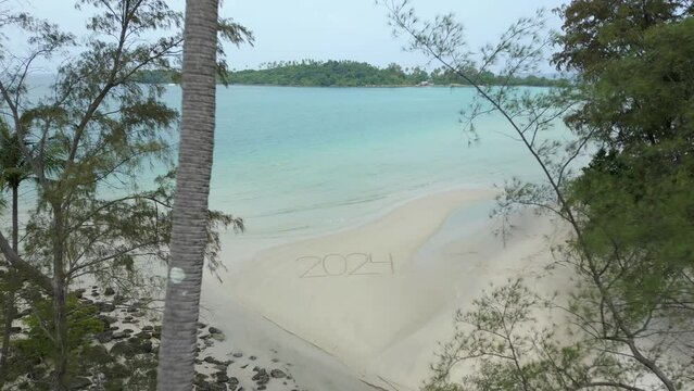 Amazing view of 2024 written on the white sandy beach in tropical paradise scenery. Concept of a beach getaway in 2024.