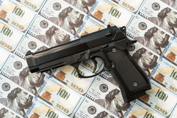 black gun on background of cash dollars. the concept of criminal money or murder for money. bank...