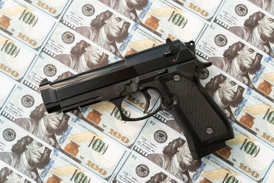 black gun on background of cash dollars. the concept of criminal money or murder for money. bank robbery,