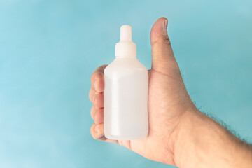 A white woman's hand holding a medicine used to clear the airways. Solution applied directly to the nose with oxymetazoline hydrochloride as its main compound. Contains 15 milliliters in the bottle.