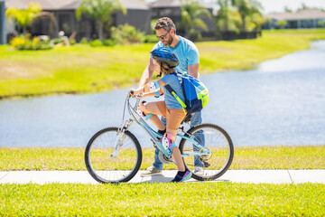 Obraz premium dad and son enjoying fun bike outing. dad and son on biking adventure. dad and son duo pedaling through picturesque landscape. Meaningful family interactions. dad guiding his son first bike ride