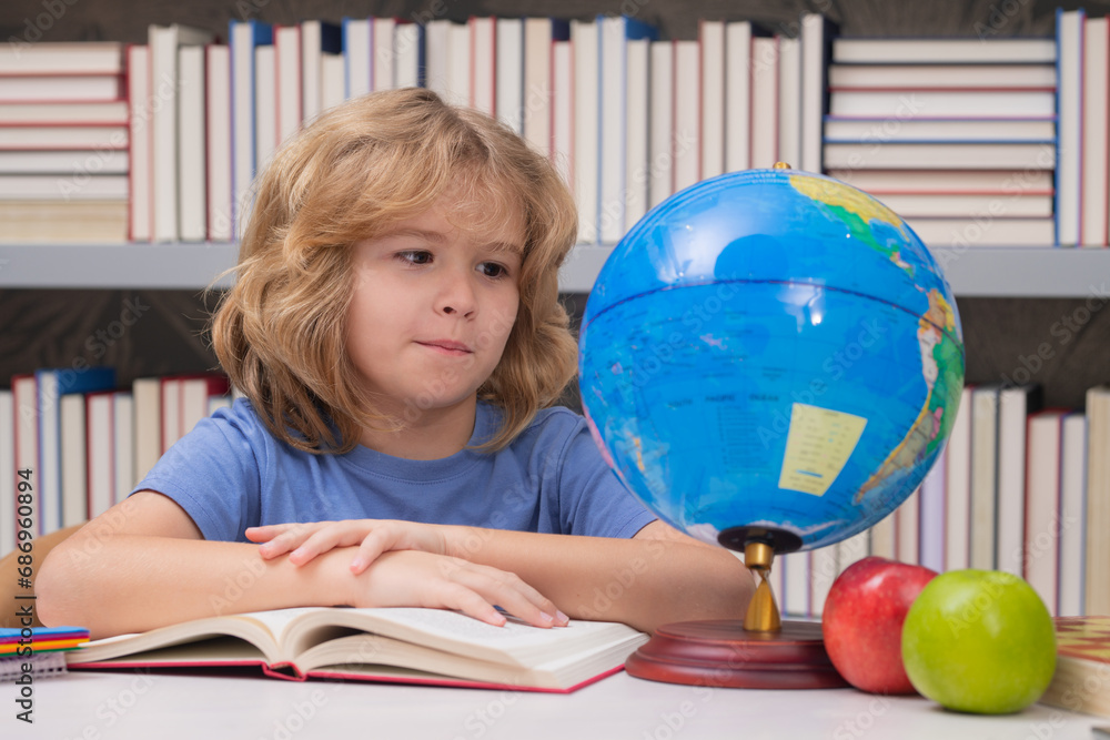 Poster school pupil looking at globe in library at the elementary school. world globe. kid boy from element