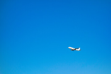 Naklejka na ściany i meble 青空を背景に飛行する飛行機