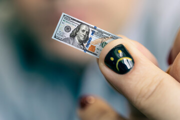 A young businessman guy holds a small bill in his hand as a symbol of declining income. Small...
