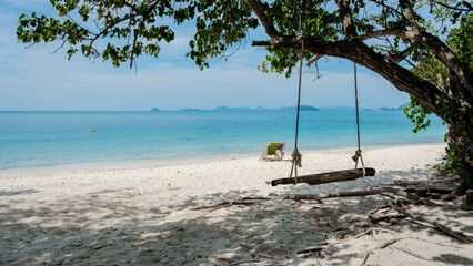a swing under a tree at the beach of Ko Kham Island Sattahip Chonburi Samaesan Thailand, a tropical island with turqouse colored ocen in Thailand
