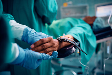 Close up of surgical nurse holding patient's hand in operating room. - obrazy, fototapety, plakaty