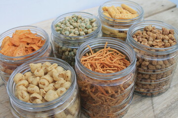 Rows of Indonesian various snacks in jars on the  table 