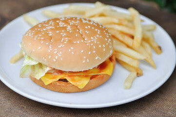 burger or pork burger or hamburger or beef burger , bun and French fries