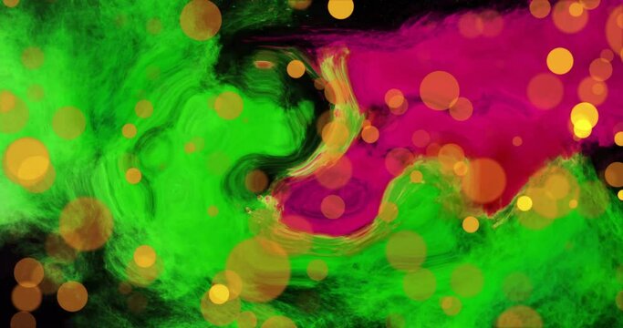 Animation of orange light orbs over green and pink blots