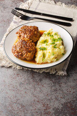 Hutspot met Gehaktballen Dutch Mashed Potatoes with Meatballs closeup on the plate on the table. Vertical