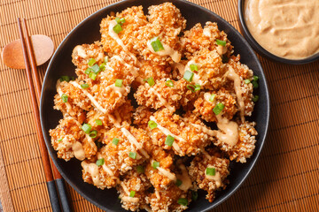 Bang Bang Chicken crispy bites and spicy sauce that will wow your taste buds closeup on the plate on the table. Horizontal top view from above