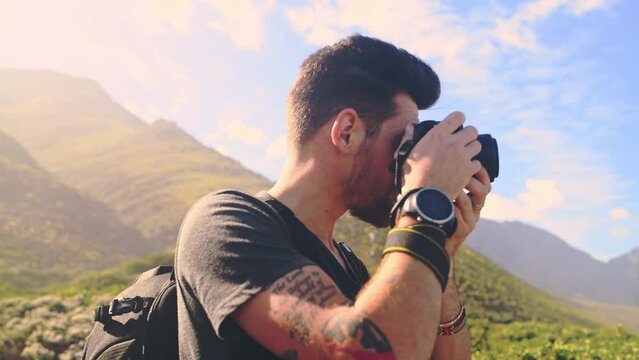 Man, camera and tourist on hike, outdoors and mountains for photography, travel and freedom on adventure. Male person, journey and photo in nature, picture and exploration or sightseeing holiday trip