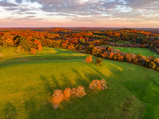 Obraz premium aerial view of autumn trees on the hill under dusk sunlight