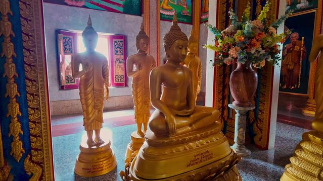 .scenery Golden Buddha statues in beautiful pagoda at Chalong temple..The Dhamma practice room is beautifully decorated with Buddha statues .in various postures arranged in an orderly manner.