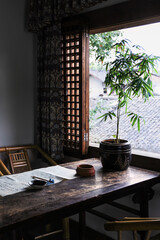 Wooden table with calligraphy utensils with backlit from vintage wooden window - a place for meditation