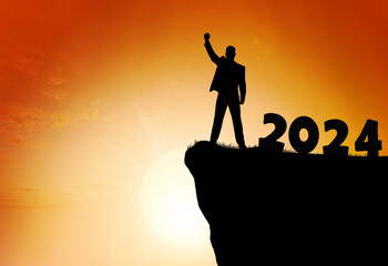 Man raise hand up on sunset sky at top of mountain, 2024 for New Year