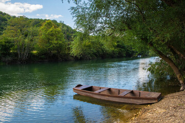 Naklejka na ściany i meble A wooden boat on the River Una north of Martin Brod, Bihac, in the Una National Park. Una-Sana Canton, Federation of Bosnia and Herzegovina. Early September