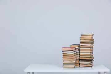 A simple composition of many books, stack or pile of books on wooden table, one of them open with copy space.