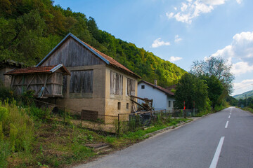 Fototapeta na wymiar Houses on a country road just north of Martin Brod, Bihac, in the Una National Park. Una-Sana Canton, Federation of Bosnia and Herzegovina. Early September