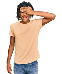 Young african american man wearing casual clothes smiling and laughing with hand on face covering...