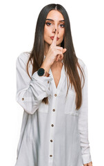 Young beautiful woman wearing casual white shirt asking to be quiet with finger on lips. silence and secret concept.