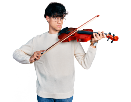 Handsome hipster young man playing violin relaxed with serious expression on face. simple and natural looking at the camera.