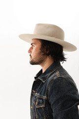 Fashionable bearded young man wearing hat posing on the white background.