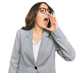 Young brunette woman wearing business clothes shouting and screaming loud to side with hand on mouth. communication concept.