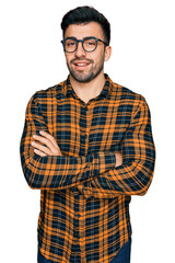 Hispanic man with beard wearing casual clothes and glasses happy face smiling with crossed arms looking at the camera. positive person.