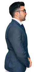 Hispanic man with beard wearing business suit and tie looking to side, relax profile pose with...