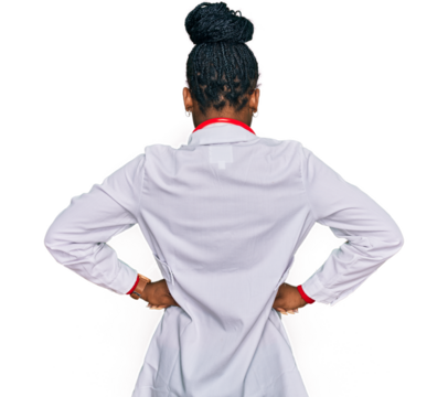 Young african american woman wearing doctor uniform and stethoscope standing backwards looking away with arms on body - Powered by Adobe