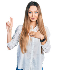 Beautiful caucasian woman wearing casual white shirt smiling swearing with hand on chest and...