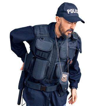 Young handsome man wearing police uniform suffering of backache, touching back with hand, muscular pain
