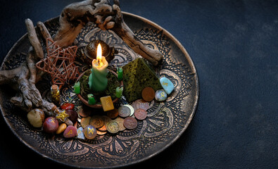 money magic. Witch altar with candles, different old coins, stone runes, pentacle on dark table...