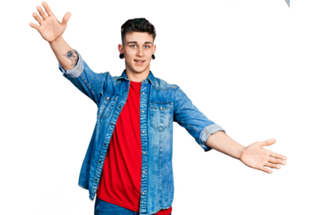 Young caucasian boy with ears dilation wearing casual denim jacket looking at the camera smiling with open arms for hug. cheerful expression embracing happiness.