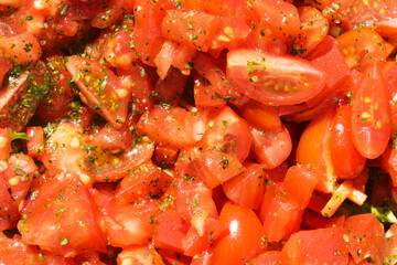 Cut tomatoes with olive oil. Tomatoe salad closeup background. Chopped tomatoes texture. Red vegetable background. Shiny healthy salad. Fresh homemade tomatoes with spices tasty dressing top view.