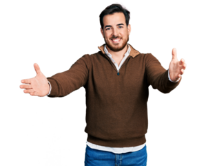Young hispanic man wearing casual clothes looking at the camera smiling with open arms for hug. cheerful expression embracing happiness.